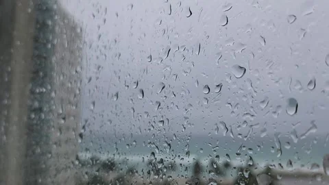 Raindrops flowing down window glass with moving background rainy weather texture Stock Footage 331347326