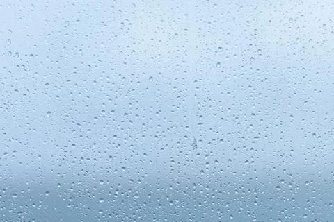 Raindrops forming a delicate pattern on a window pane, blurring the outside.. Foto stock