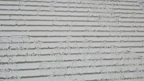 Raindrops on glass against the background of a striped wall Stock Footage 130921941