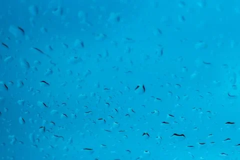 Raindrops on glass on a blue background Stock Photos