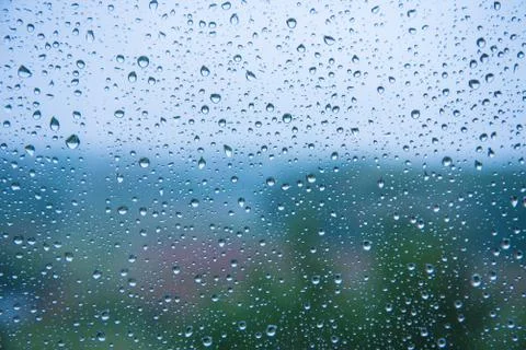 Raindrops on the glass close-up. Background texture. Bad weather. Blue cold s Stock Photos