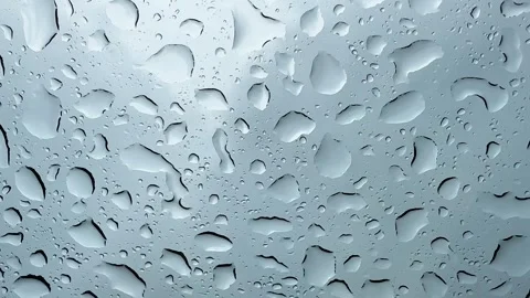 Raindrops on glass in close-up. Rainy day raindrops on window as relaxing Stock Footage 245362012