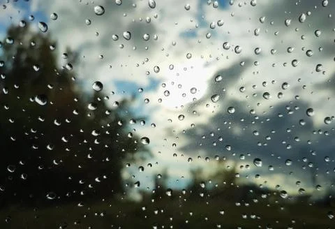 Raindrops on glass on a landscape background Stock Photos