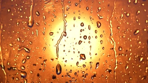 Raindrops on glass by the light of the sun 動画素材 220568633