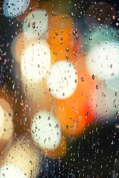 Raindrops on glass at night Stock Photos