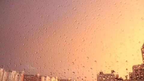 Raindrops on the glass. There is a pink-peach sunset outside the window Stock Footage 194453485