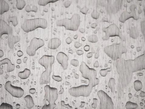 Raindrops on a gray rough metal surface Stock Photos