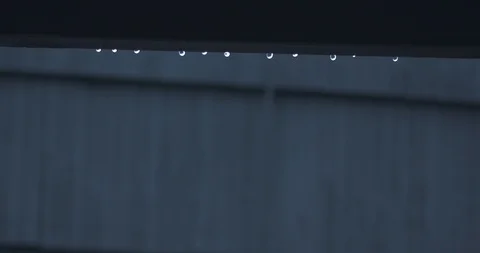 Raindrops on the Gutter of a House as it Continues to Rain in the Background Stock Footage 104263473