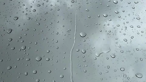Raindrops hit the glass while dark rain clouds fill the overcast sky. Stock Footage 345838784
