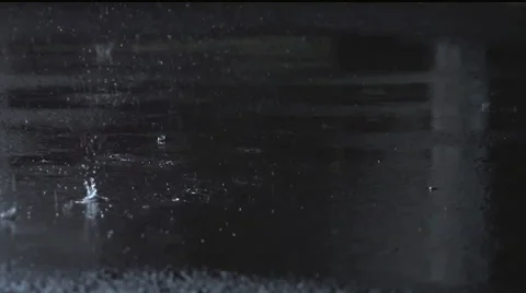 Raindrops hitting ground in slow motion Stock Footage 53207354