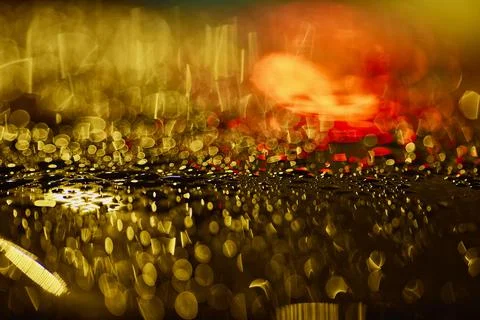 Raindrops large on the surface illuminated by a colored lantern Foto stock