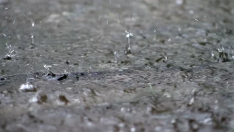 Raindrops make small bubbles in puddles Stock Footage 130955631