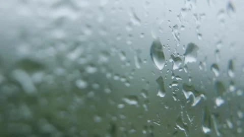 Raindrops merge and trickle down glass with delicate reflections and soft blur Video stock 324625355