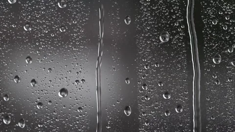 Raindrops merging and sliding on wet glass during a gray lightning storm. Stock Footage 326452971