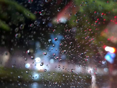 Raindrops at night on car window against city backdrop in Bangkok, Thailand 스톡 동영상 262491755