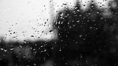 Raindrops on a old window with contrast by light sky and dark vegetation Foto stock