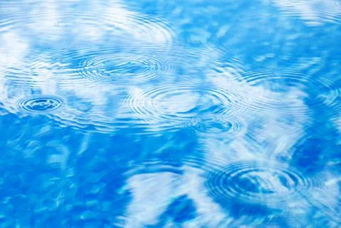 Raindrops on pool blue water surface. Blue water texture as background. Stains Stock Photos