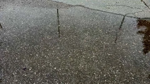 Raindrops in a puddle on the asphalt Stock Footage 304358676