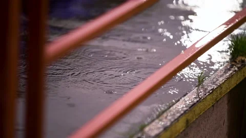 Raindrops on puddle bright lantern reflection pedestal orange color handrails Stock Footage 147937322
