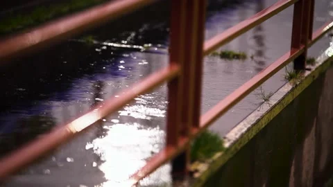 Raindrops on puddle bright lantern reflection pedestal orange color handrails Stock Footage 147937335