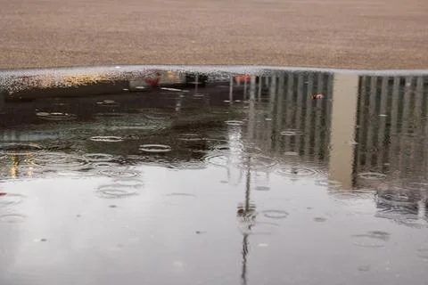 Raindrops on a puddle in the city Stock Photos