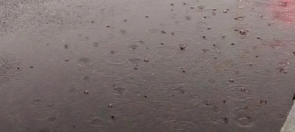 Raindrops on a puddle on the road Stock Photos