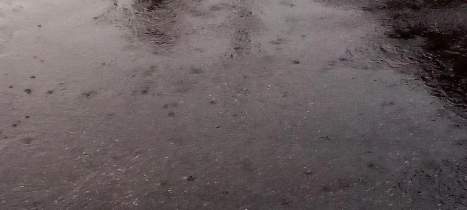 Raindrops on a puddle on the road Foto stock