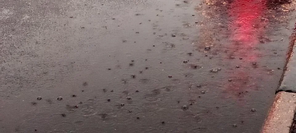 Raindrops on a puddle on the road Stock Photos
