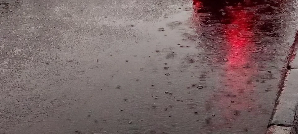 Raindrops on a puddle on the road Stock Photos