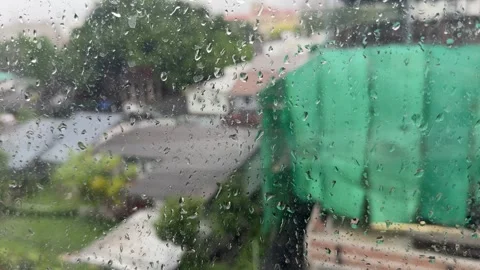 Raindrops resting on a window pane during a rainy day Stock Footage 337977045