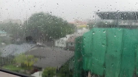 Raindrops resting on a window pane during a rainy day Stock Footage 337977336