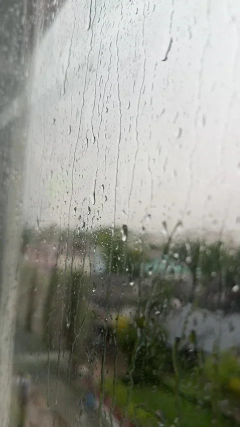 Raindrops resting on a window pane during a rainy day Stock Footage 337977385