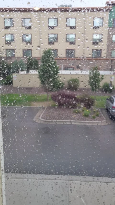 Raindrops roll down, streaking window glass, blurring building across the road 스톡 동영상 340237834