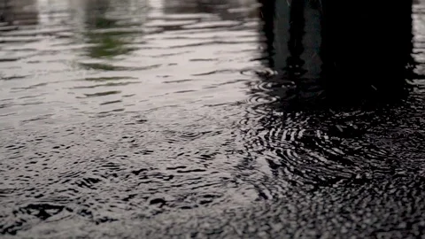 Raindrops from the roof fall into a puddle slow motion Stock Footage 126972638