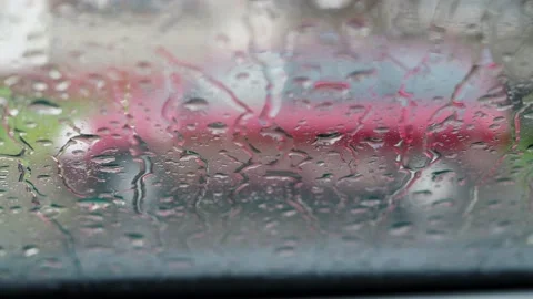 Raindrops run down the car window. the car is in the parking lot. there is a car Stock Footage 166631315