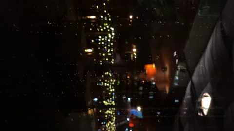 Raindrops run down the glass, against the background of the city, at night Stock Footage 240952167