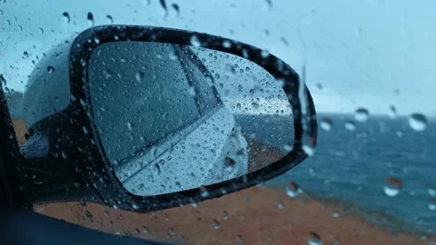 Raindrops run down the glass and mirror of the car 스톡 동영상 131180525