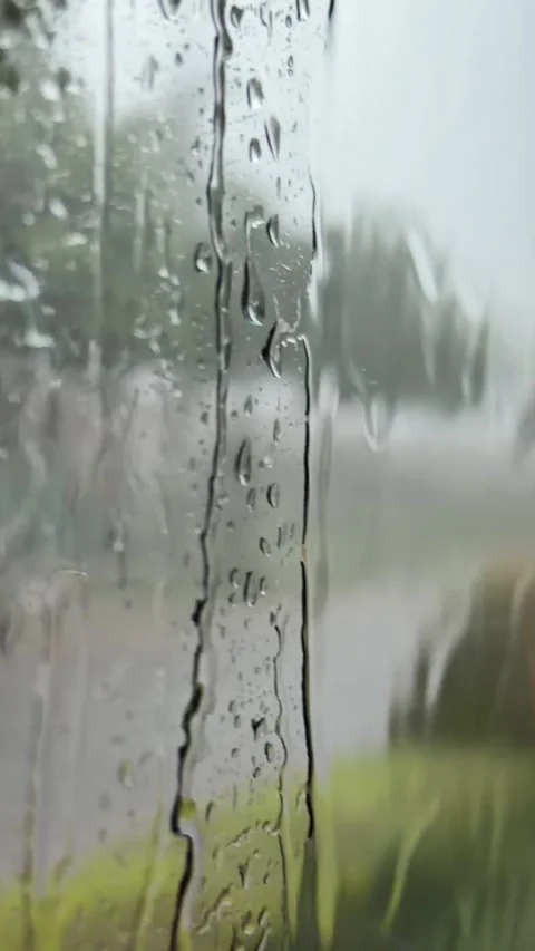 Raindrops run down a vehicle window with vegetation and roadside surroundings vi Stock Footage 340150216