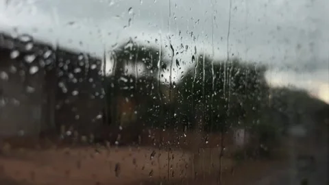 Raindrops run down a window during travel with trees and roadside surroundings v Stock Footage 339279897