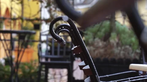 Raindrops running down the back of a black metal chair outside. The autumn Stock Footage 267755390