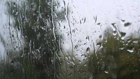 Raindrops running down a window pane on a grey rainy autumn day Stock Footage 343568776
