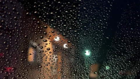 Raindrops sliding down car windscreen at night Stock Footage 231372419