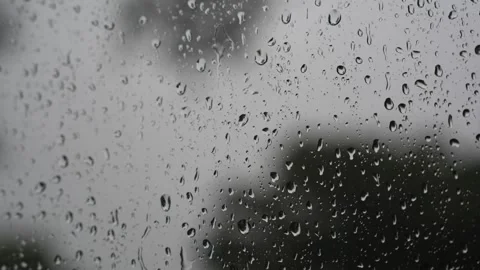 Raindrops sliding down a glass window pane on a rainy day Stock Footage 340833327