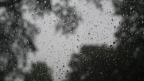 Raindrops sliding down a glass window pane on a rainy day Stock Footage 340833640