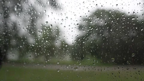 Raindrops sliding down a glass window pane on a rainy day Stock Footage 340833883