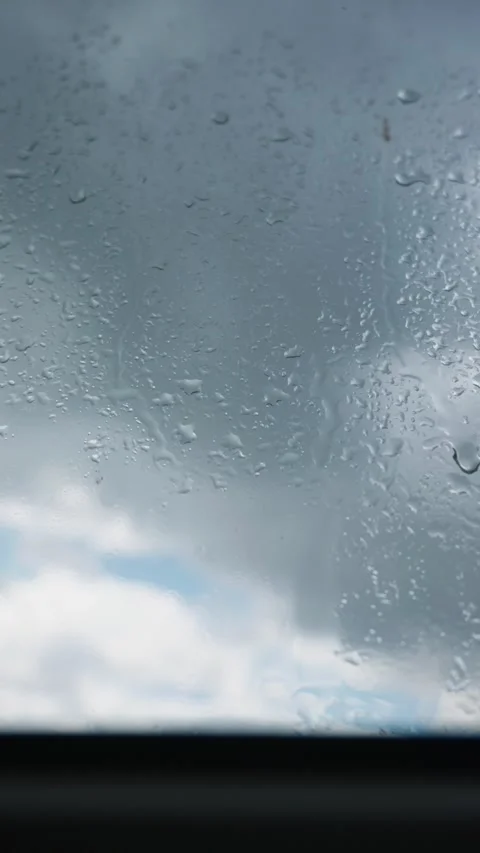 Raindrops Sliding Down Glass Window Under Overcast Sky Close-Up Video stock 345426744