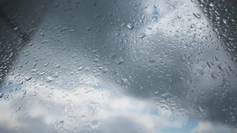 Raindrops Sliding Down Window Glass Against Overcast Cloudy Sky Stock Footage 345426390