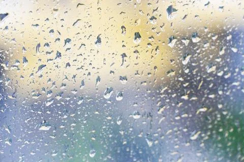 Raindrops sliding on the window glass surface, tropical rain Stock Photos
