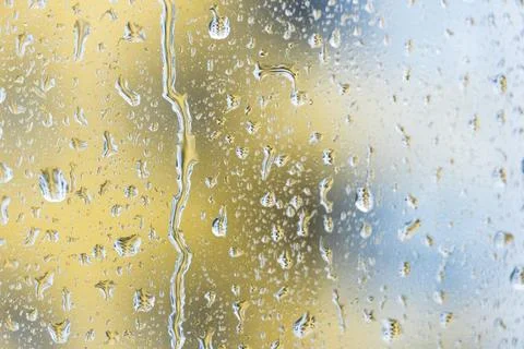 Raindrops sliding on the window glass surface, tropical rain Stock Photos