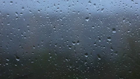 Raindrops slowly slide down the window glass, downpour, rainy season Video stock 333649632